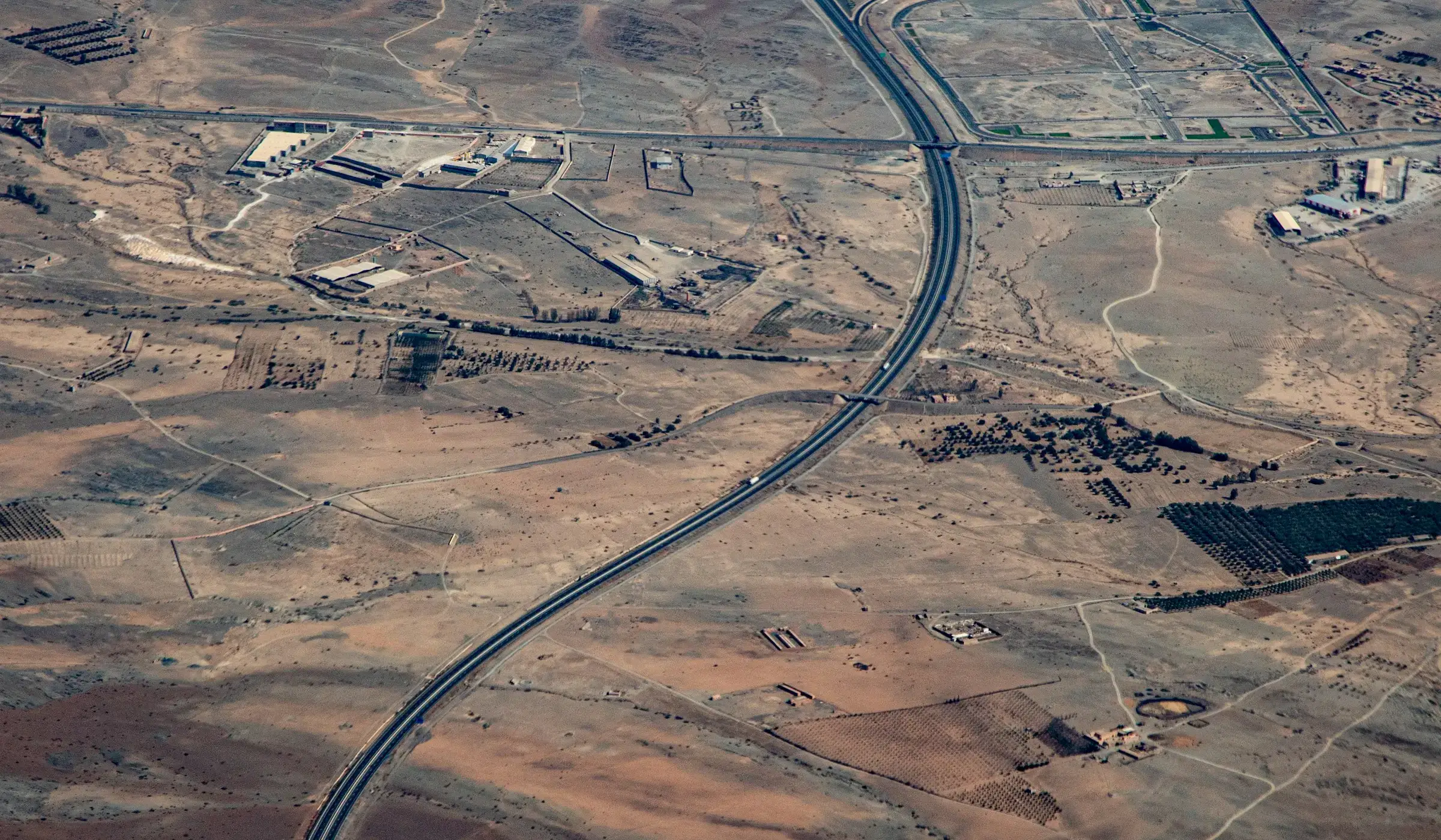 Aerial view of a highway curving through an arid landscape